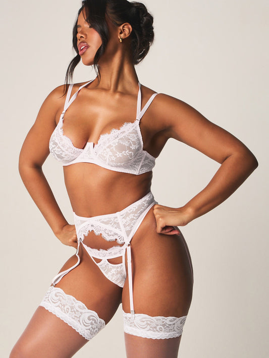 Conjunto de lencería seductora de encaje blanco con sujetador con aros, liguero y medias